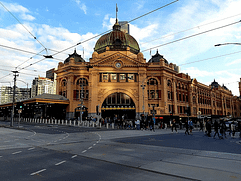 An image of the Melbourne train station. Tall yellow building with a dome in the style of French Renaissance architecture.